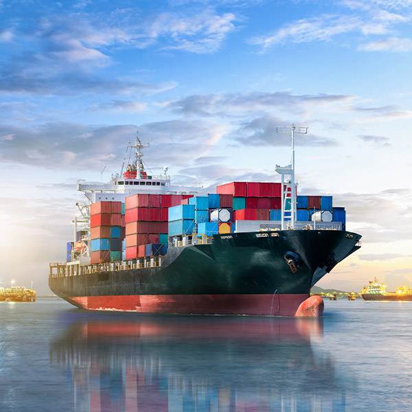 A Dependable Cargo Ship With Colourful Containers Glides At Sunset, Showcasing Reliability Like Kingfisher'S Top-Quality Grease Fittings.