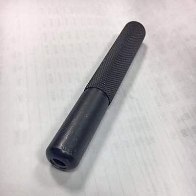Premium Drive Tool With Black Textured Metal Body And Curved Handle, Shown On Paper—Ideal For High-Performance Grease Nipples.